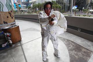 Elvis impersonator Michael Romeo tries to control his cape  in the wind while working on the Strip Thursday, Jan. 30, 2014. Romeo worked on Hollywood Boulevard in Los Angeles for 12 years before moving to the Las Vegas Strip two years ago.