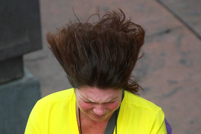 A woman's hair blows in the wind while she walks down the Strip as a weather system moves through the valley Thursday, Jan. 30, 2014.