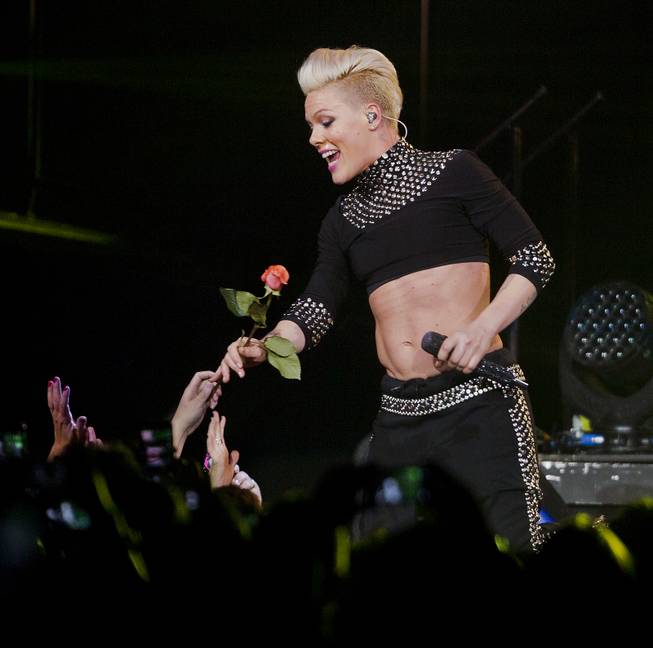 Pink gets down low and accepts a rose from a fan during her performance at the MGM Grand Garden Arena on Friday, Jan. 31, 2014.