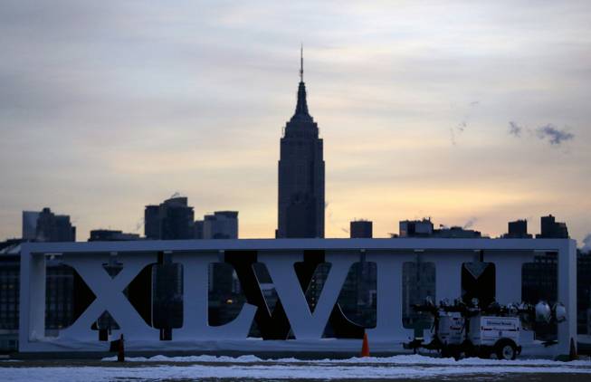 The Empire State Building, top, backdrops Roman numerals for the NFL Super Bowl XLVIII football game during sunrise at Pier A Park in Hoboken, N.J., Tuesday, Jan. 28, 2014. The Seattle Seahawks and the Denver Broncos are scheduled to play on Sunday, Feb. 2, 2014, at MetLife Stadium in East Rutherford, N.J. 