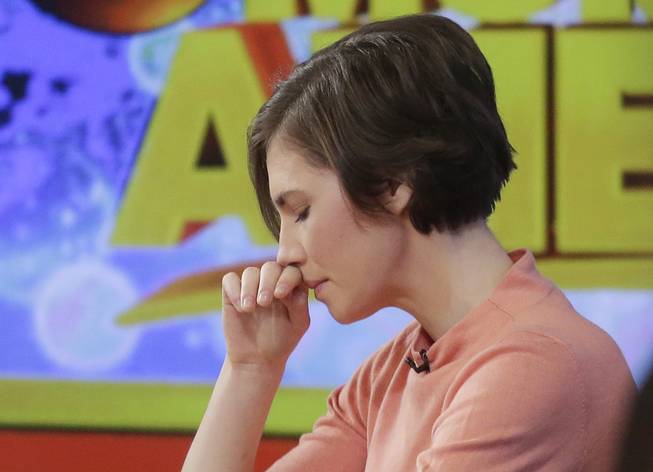 Amanda Knox puts her hand to her face while making a television appearance, Friday, Jan. 31, 2014, in New York. Knox said she will fight the reinstated guilty verdict against her and an ex-boyfriend in the 2007 slaying of a British roommate in Italy and vowed to "never go willingly" to face her fate in that country's judicial system . "I'm going to fight this to the very end," she said in an interview with Robin Roberts on ABC's "Good Morning America."