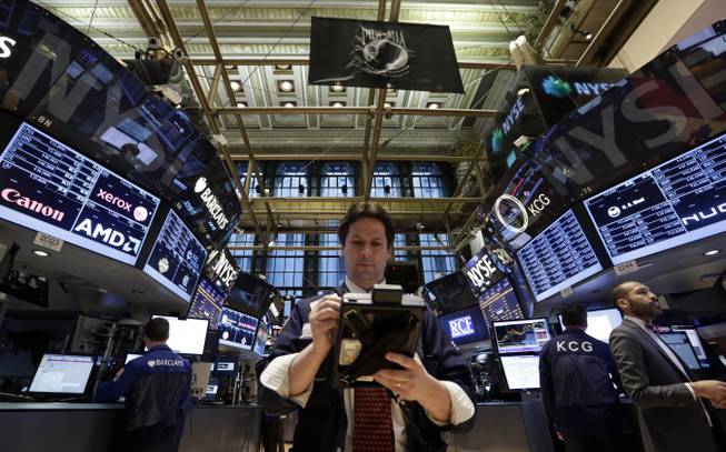 In this Thursday, Jan. 30, 2014, file photo, Trader Patrick McKeon, center, works on the floor of the New York Stock Exchange.