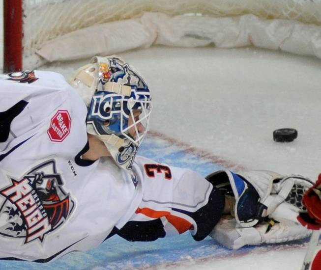 Ontario Reign goaltender Jussi Olkinuora reaches for a puck as it skitters into the net first period Wranglers goal on Friday night at the Orleans Arena.