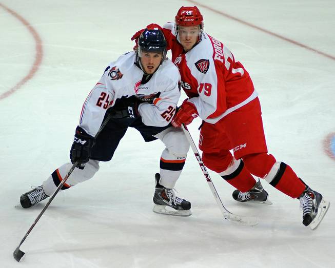 Las Vegas Wranglers defenseman Ryan Forgaard battles for position with Ontario Reign right winger Sebastian Stalberg during an ECHL game on Saturday night at the Orleans Arena.