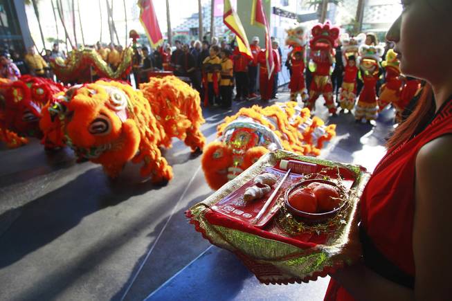 A woman holds supplies for a "Dotting of the Eyes" ceremony as the Cosmopolitan marks the Year of the Horse Saturday, Feb. 1, 2014.