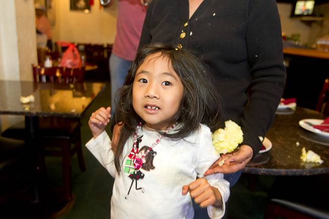 Evelyn Wong, 5, is covered in bits of lettuce after a lion dance at the Kung Fu Thai & Chinese Restaurant,3505 S. Valley View Blvd. Sunday, Feb. 2, 2014. The traditional ceremony, performed by the Lohan School of Shaolin, was staged to drive out any evil spirits from the business.