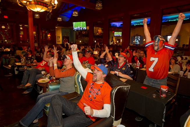 Denver fans Tim Frame, left, and Jason Platt, both originally from Colorado, cheer on the Broncos as they watch Super Bowl XLVIII from the Roadrunner Saloon, 9820 W. Flamingo Rd., Sunday, Feb. 2, 2014.