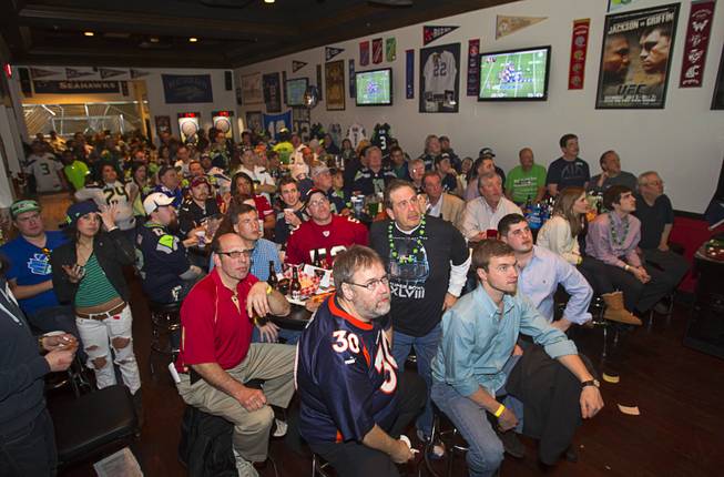 Seattle Seahawks fans are focused on a big screen as they watch Super Bowl XLVIII from a converted game area in Scooters Pub, 6200 S. Rainbow Blvd., Sunday, Feb. 2, 2014.