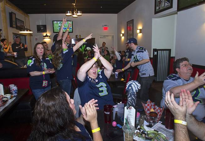 Fans cheer a play by the Seattle Seahawks as they watch Super Bowl XLVIII from Scooters Pub, 6200 S. Rainbow Blvd., Sunday, Feb. 2, 2014.