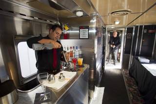 Eddie Ybarra, an event captain with Masterpiece Cuisine, mixes drinks during a tour of X Train Club cars Tuesday, Feb. 4, 2014.