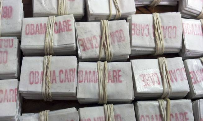 This photo released on Friday, Dec. 20, 2013 by the Massachusetts State Police via Facebook shows some of the 1,250 packets of heroin labeled "Obamacare" and "Kurt Cobain" which state police troopers confiscated during a traffic stop in Hatfield, Mass. Four people were charged with heroin trafficking.