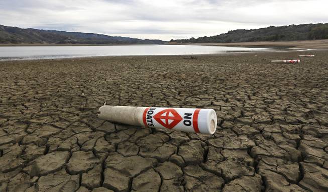 In this Tuesday, Feb. 4, 2014, photo, a warning buoy sits on the dry, cracked bed of Lake Mendocino near Ukiah, Calif. Despite recent spot rains, the reservoir is currently only about 37 percent full. California is amid a historic drought, prompting Gov. Jerry Brown to declare a state of emergency.
