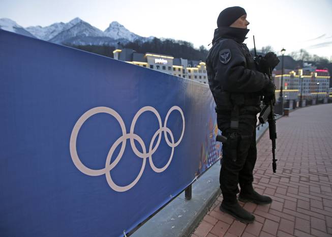 An armed Russian security guard stands at the ski resort Rosa Khutor, where the snow and sliding sports venues for the 2014 Winter Olympics are located, Tuesday, Feb. 4, 2014, in Krasnaya Polyana, Russia.