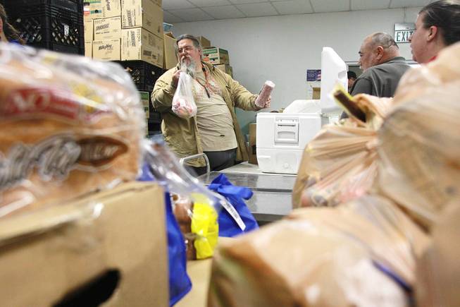 Volunteer Shane Smith pulls frozen items to add to a box of food at Our Savior Church's food line Wednesday, Feb. 5, 2014 in Henderson.