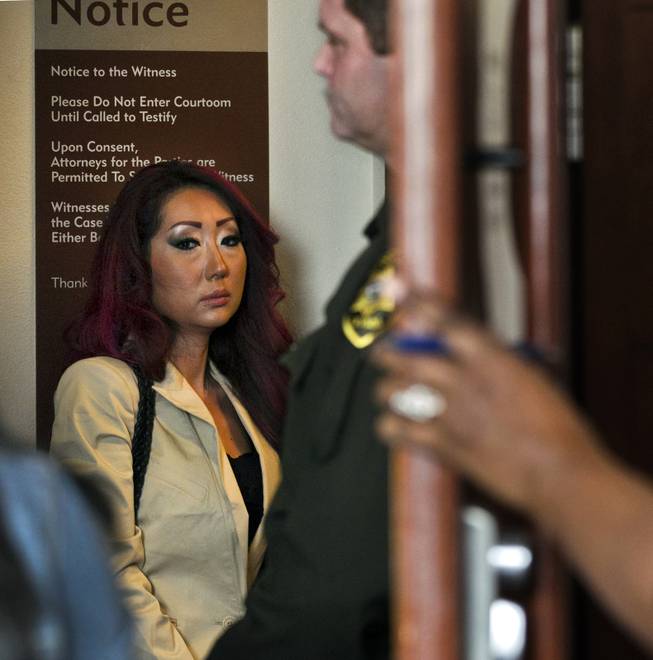 Gloria Lee, accused of arson and animal cruelty in connection with a fire at her pet store, Prince and Princess Pet Boutique, awaits her escort to leave the courtroom  Wednesday, Feb. 5, 2014.