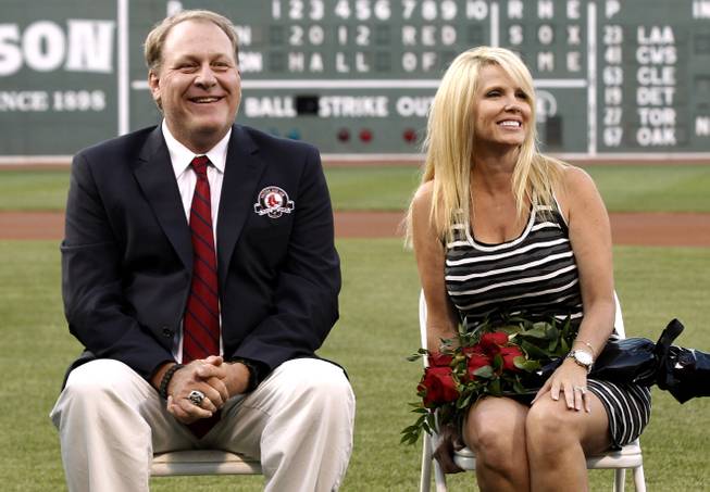 Former Boston Red Sox pitcher Curt Schilling sits with his wife, Shonda, right, after being introduced as a new member of the Boston Red Sox Hall of Fame before a baseball game between the Boston Red Sox and the Minnesota Twins at Fenway Park in Boston, Friday, Aug. 3, 2012.