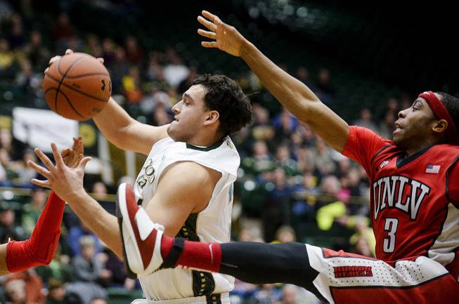Colorado State's J.J. Avila, center, and UNLV's Kevin Olekaibe come down from the basket during the second half of an NCAA college basketball game Wednesday, Feb. 5, 2014, at Moby Arena in Fort Collins, Colo. Colorado State won 75-57. 