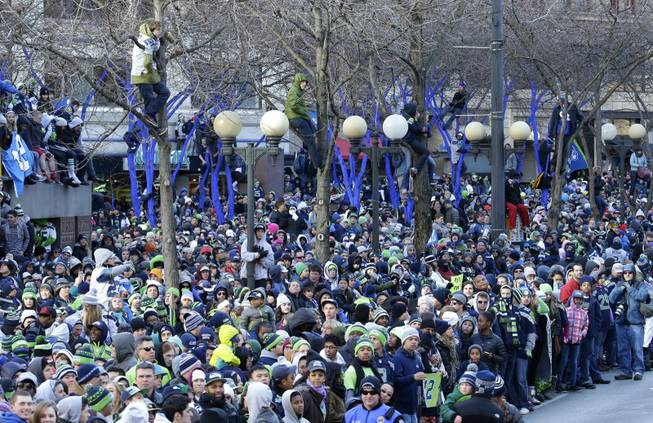 Seattle Seahawks fans watch as the Seahawks pass by during the parade for the NFL football Super Bowl champions on Wednesday, Feb. 5, 2014, in Seattle. 