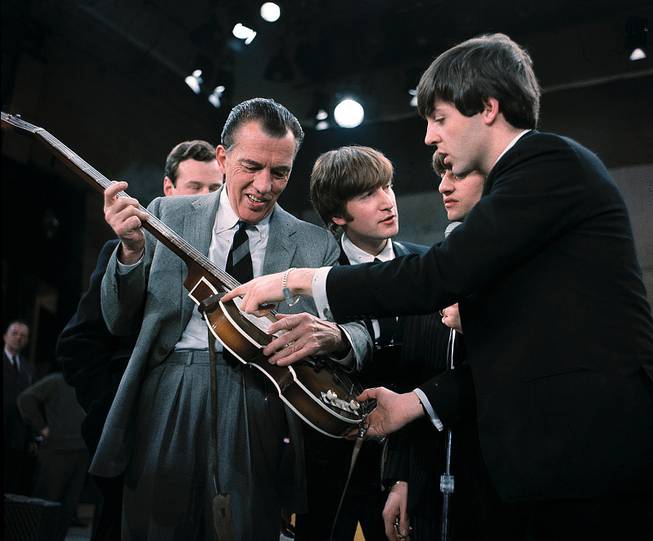 Paul McCartney, right, shows his guitar to host Ed Sullivan before The Beatles' live TV appearance on "The Ed Sullivan Show" in New York on Feb. 9, 1964.