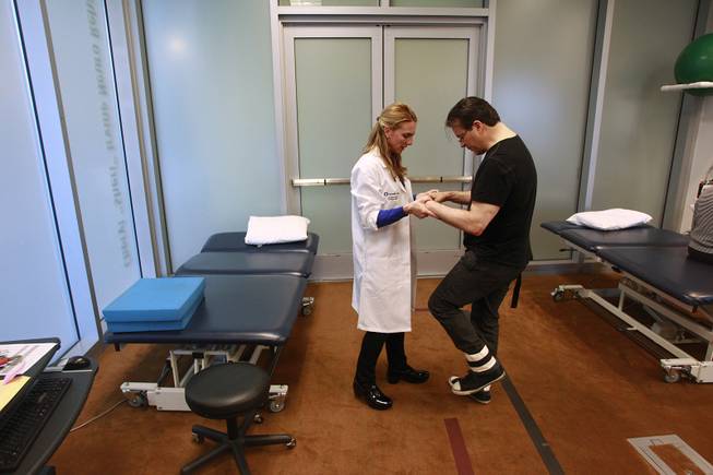 Physical therapist Jen Nash helps Kerry Simon walk across the room during a therapy session at the Cleveland Clinic Lou Ruvo Center for Brain Health on Feb. 7, 2014.