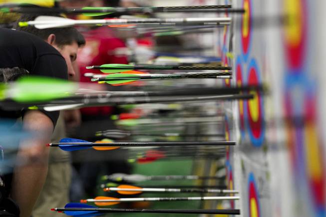 Archers verify points and retrieve their arrows during the Adult Freestyle Championship in the South Point Arena as part of the Vegas Round of the 2014 NFAA World Archery Festival on Friday, Feb. 7, 2014.