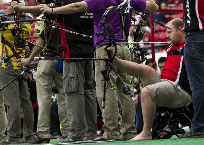 Archer Matt Stutzman of Fairfield, Iowa, holds his bow and releases arrows using only his feet on Friday, Feb. 7, 2014. He shot one of the top scores during the Adult Freestyle Championship in the South Point Arena in the Vegas Round of the 2014 NFAA World Archery Festival.
