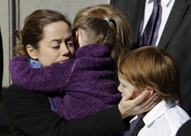 Mimi O'Donnell, estranged partner of actor Philip Seymour Hoffman, comforts two of their children, daughter Willa, and son Cooper as his casket arrives at the Church of St. Ignatius Loyola, Friday, Feb. 7, 2014 in New York. Hoffman, 46, was found dead Sunday of an apparent heroin overdose.