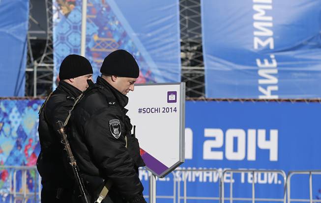 Russian Special Rapid Response Unit personnel patrol the parameters of the Olympic cauldron, ahead of the 2014 Winter Olympics opening ceremony, Friday, Feb. 7, 2014, in Sochi, Russia.