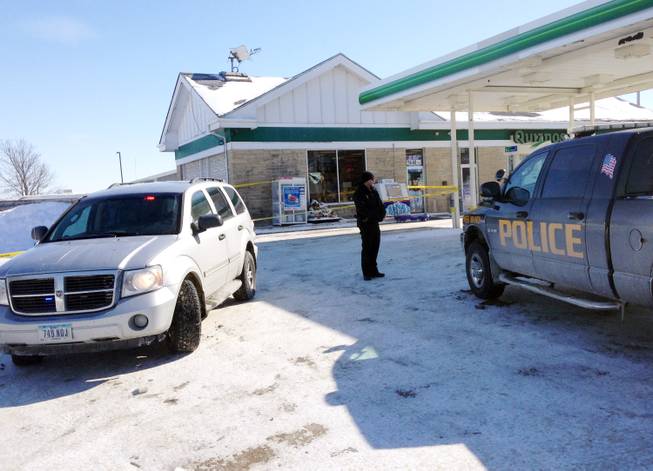 Authorities gather at a gas station in West Branch, Iowa, where a missing newborn was found alive Friday, Feb. 7, 2014. Police said they found Kayden Powell, who's nearly a week old, after they heard the newborn crying and found the child swaddled in blankets inside a tote bag outside the gas station. Police said the baby was in excellent health. 