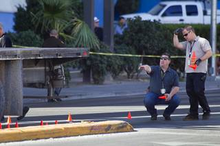 Metro Police investigators look over the scene of an auto pedestrian accident at Flamingo Road and Linq Lane (between Koval Lane and the Las Vegas Strip) Tuesday Feb. 11, 2014.