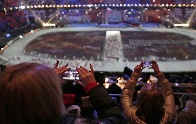 A spectator takes a video of the opening ceremony on her mobile phone at the 2014 Winter Olympics in Sochi, Russia, Friday, Feb. 7, 2014. 