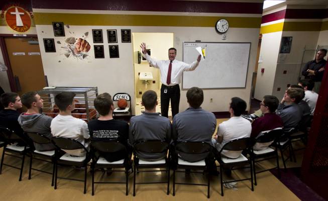 Faith Lutheran High School's CEO Dr. Steve Buuck gives the devotional to varsity basketball players before the start of their game against Pahrump on Thursday, Feb. 13, 2014.