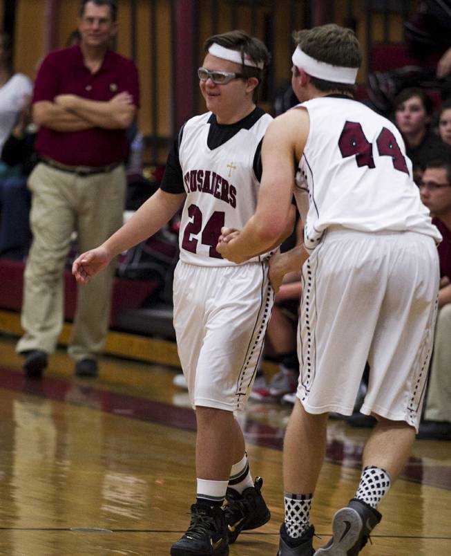 Faith Lutheran senior Clayton Rhodes is welcomed onto the court by teammate Brock Smith in the fourth period of their game against Pahrump on Thursday, Feb. 13, 2014.