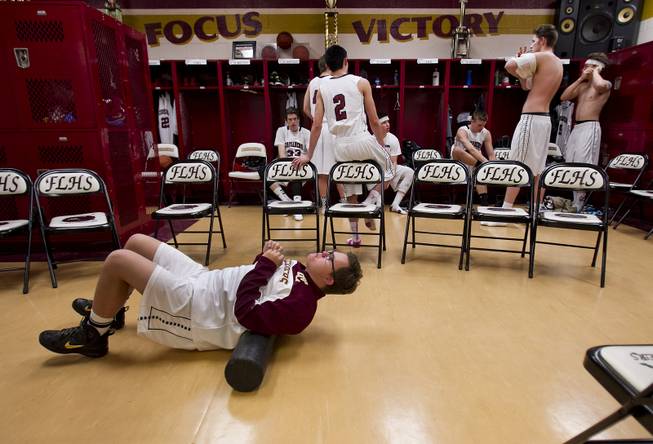 Faith Lutheran senior Clayton Rhodes stretches out as he and varsity basketball teammates ready in their locker room before the start of their game against Pahrump on Thursday, Feb. 13, 2014.