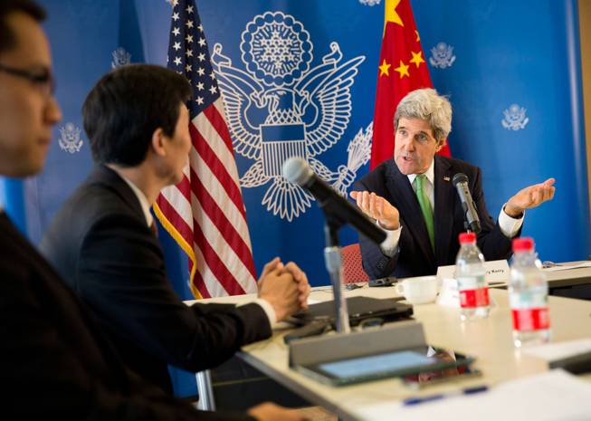 U.S. Secretary of State John Kerry, right, gestures during a discussion with Chinese bloggers on a number of issues, including internet freedom, Chinese territorial disputes with Japan, North Korea, and human rights, on Saturday, Feb. 15, 2014, in Beijing, China.