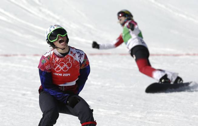 Czech Republic's Eva Samkova, left, celebrates after taking the gold medal in the women's snowboard cross final, ahead of silver medalist Dominique Maltais of Canada, right, at the Rosa Khutor Extreme Park, at the 2014 Winter Olympics on Sunday, Feb. 16, 2014, in Krasnaya Polyana, Russia.