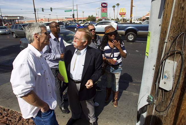 Volunteer Edward Cotton, center, talks with Jeff Hoffman, left, and other passers-by as he searches for information on missing woman Jessie Foster near Jones Boulevard and Tropicana Avenue Monday, Feb. 17, 2014. Foster, a Canadian, went missing from North Las Vegas in 2006.