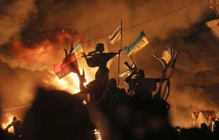 Monuments to Kiev's founders burn as anti-government protesters clash with riot police in Kiev's Independence Square, the epicenter of the country's current unrest,  Kiev, Ukraine, Tuesday, Feb. 18, 2014. 