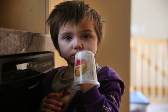 In this Feb. 7, 2014 photo, Elizabeth Burger, 4, plays with a decorative plastic cup at home in Colorado Springs, Colo. Elizabeth suffers from severe epilepsy and is receiving experimental treatment with a special strain of medical marijuana, which she takes orally as drops of oil.