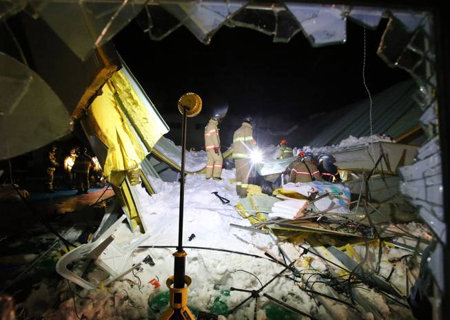 Rescue workers search for survivors from a collapsed resort building in Gyeongju, South Korea, Monday, Feb. 17, 2014.  Four university students died and about 10 were feared trapped after the roof of a building collapsed in a southeastern city during a welcoming ceremony for freshmen, South Korean officials said Tuesday.