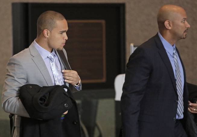 College Athletes Players Association designated President Ramogi Huma, right, and Northwestern University Wildcats' outgoing senior quarterback Kain Colter make their way to the beginning of three days of hearings before the National Labor Relations Board Tuesday, Feb. 18, 2014, in Chicago. The NLRB is scheduled to begin witness testimony on whether to approve a bid by Northwestern University football players who are trying to unionize. Colter is among the key witnesses in the case.