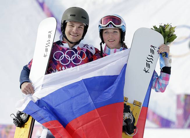 Russia's Vic Wild celebrates, after winning the gold medal in the men's snowboard parallel giant slalom final, with his wife and bronze medalist in the women's snowboard parallel giant slalom final, Russia's Alena Zavarzina, at Rosa Khutor Extreme Park at the 2014 Winter Olympics, Wednesday, Feb. 19, 2014, in Krasnaya Polyana, Russia. 