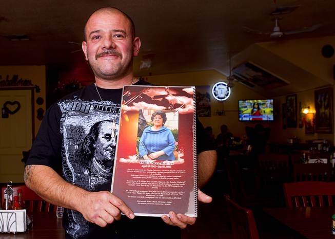 Owner David Arce poses with a menu at Los Molcajetes restaurant, 1553 N. Eastern Ave., Thursday, Feb. 20, 2014.  The back of the menu is dedicated to his mother Odilia Arce Benitez who passed away in 2010. His mother and the family opened the restaurant in 1999.