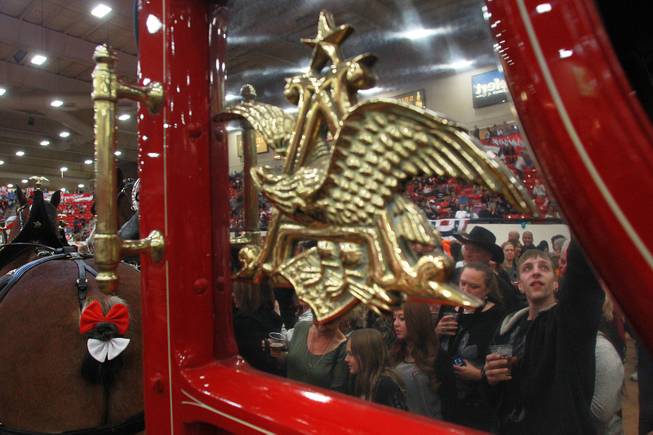 Attendees are reflected in the polished metal of the beer wagon as they get an up close look at the Budweiser Clydesdales during an appearance at the South Point Arena Thursday, Feb. 20, 2014.