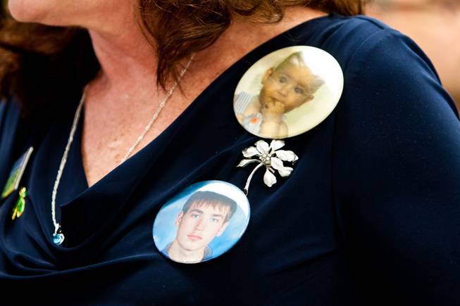 Karen Brill wears photo buttons in memory of her son 16-year-old Aric Michael Brill, who donated six organs following his homicide five years ago, during a ceremony at the UMC Transplant Center Friday, February 21, 2014.
