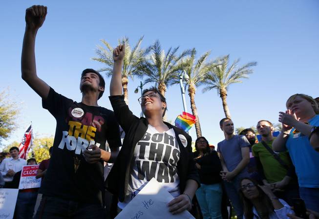 Anthony Musa, left, and Brianna Pantillione join nearly 250 gay rights supporters protesting SB1062 at the Arizona Capitol, Friday, Feb. 21, 2014, in Phoenix.