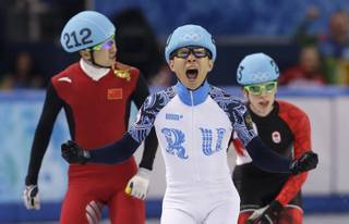 Victor An of Russia, center, reacts as he crosses the finish line ahead of Wu Dajing of China, left, and Charle Cournoyer of Canada in the men's 500m short track speedskating final at the Iceberg Skating Palace during the 2014 Winter Olympics, Friday, Feb. 21, 2014, in Sochi, Russia.