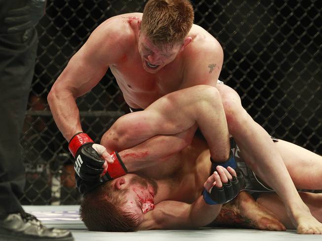 Mike Pyle pounds on T.J. Waldburger on his way to a third round TKO in their fight at UFC 170 Saturday, Feb. 22, 2014 at the Mandalay Bay Events Center.