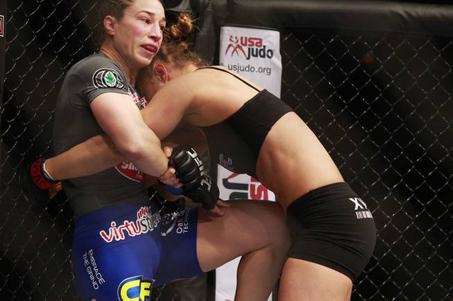 Sara McMann connects with a knee to Ronda Rousey's midsection during their fight at UFC 170 Saturday, Feb. 22, 2014 at the Mandalay Bay Events Center. Rousey won by TKO in the first round with a knee to the McMann's liver.