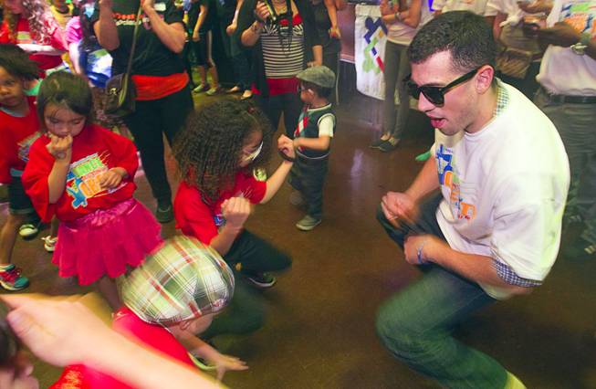 Volunteer Rob Dones dances with children during the second annual Dance Against Obesity Camp at the Marquee nightclub in the Cosmopolitan Las Vegas Sunday, Feb. 23, 2014. The free dance clinic was sponsored by TAO Cares and the Jump for Joy Foundation. While the children learned dance moves, parents participated in nutritional seminars.